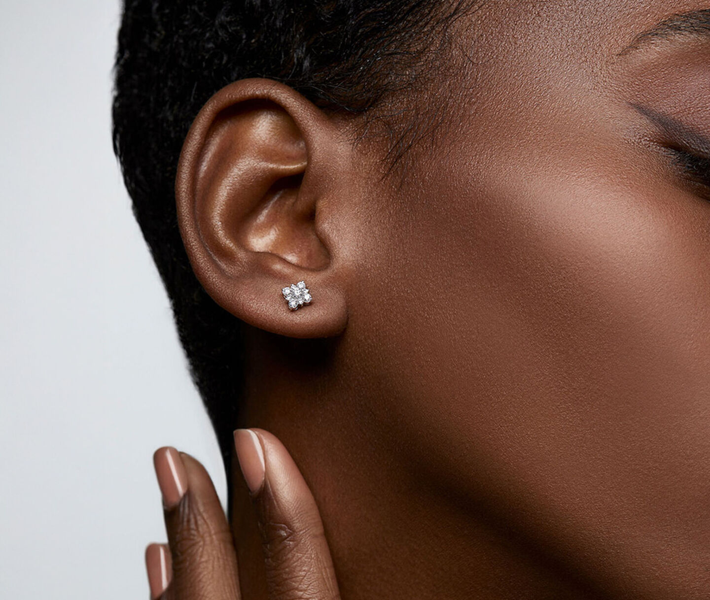 A woman wearing a Birks Snowflake diamond earrings.